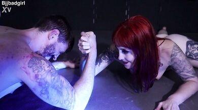 Sexy red head girl full naked doing a mixed arm wrestling fight against a muscular guy